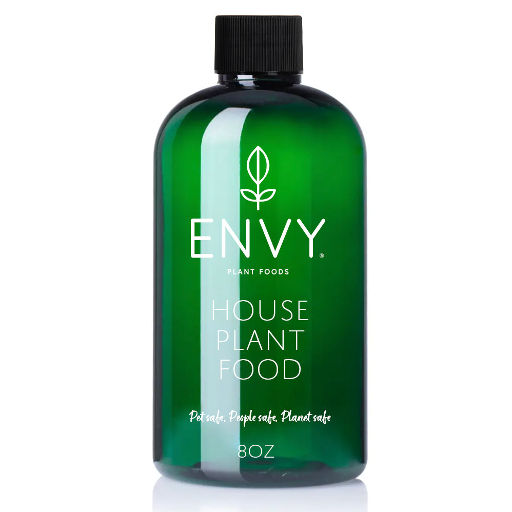 Green bottle of Envy house plant food on a white background